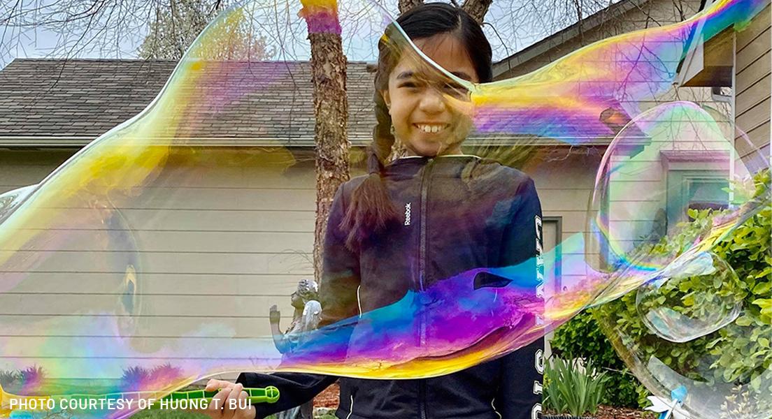 girl playing with bubble wand in wichita, kansas